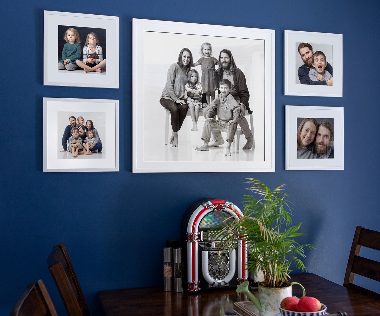 Gallery of square framed portraits on a breakfast nook wall