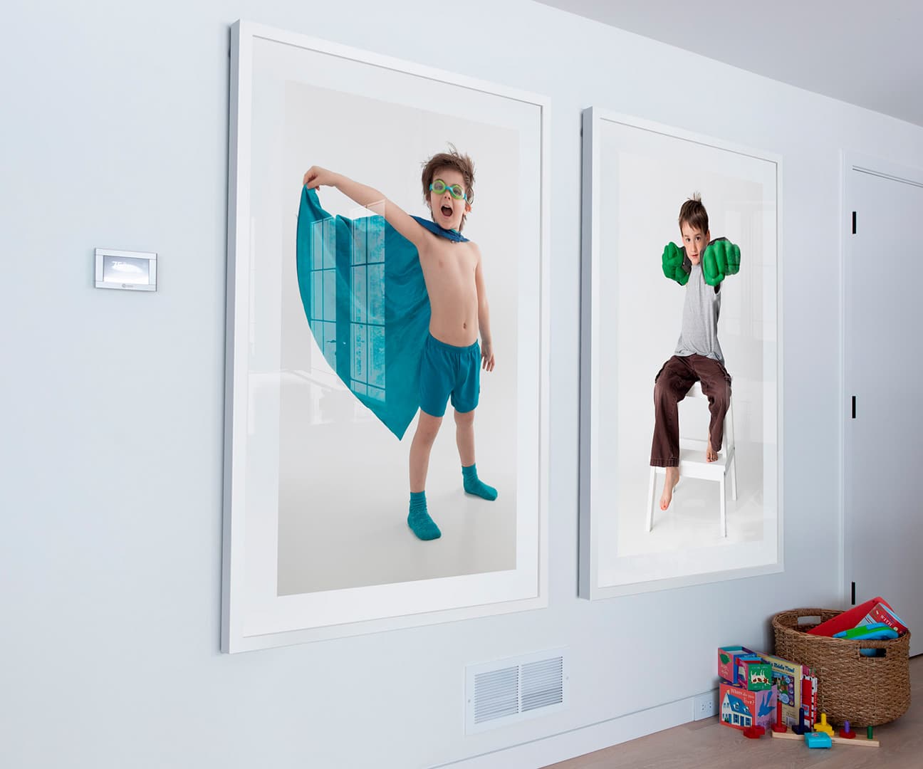 Two large framed portraits of kids in a playroom