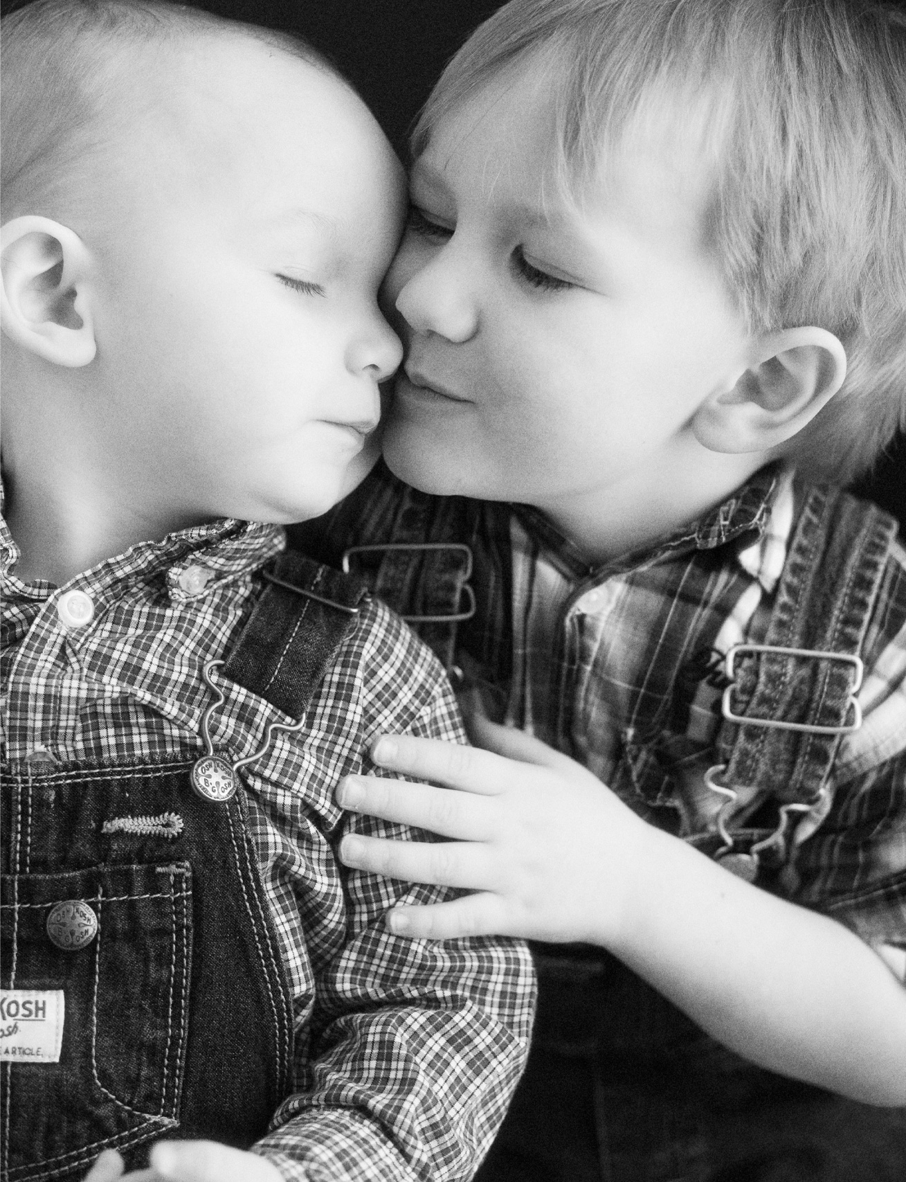 black and white portrait of two little blond brothers hugging