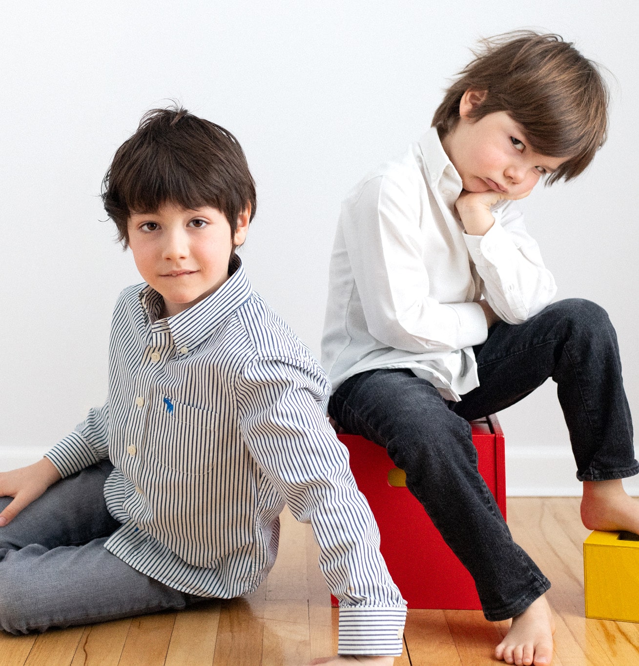 color portrait of one happy brother and one grumpy brother who doesn't want to be in the picture