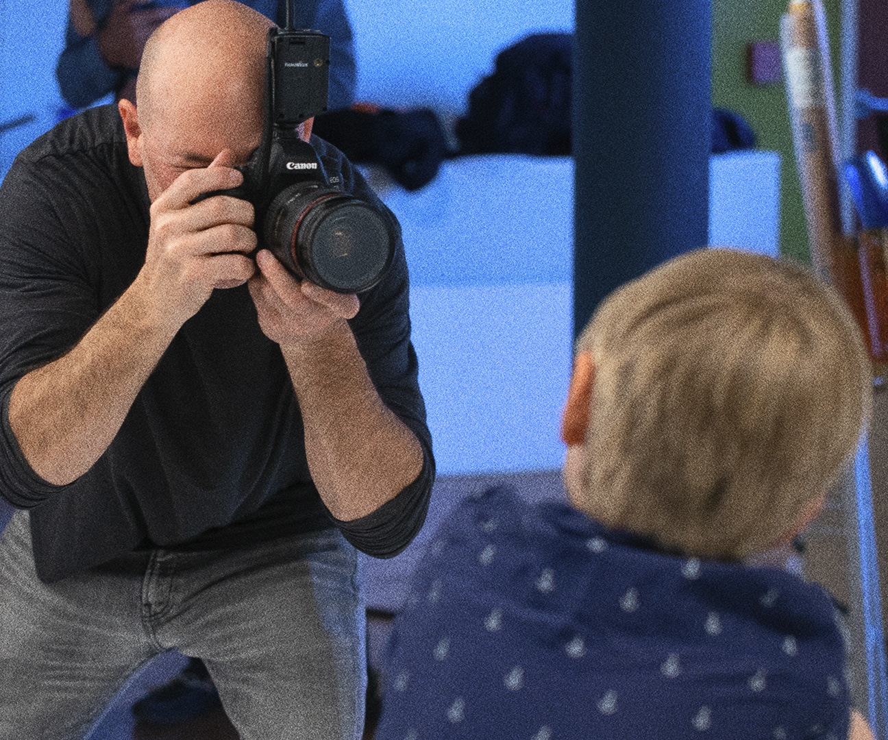 behind the scenes shot of a photographer looking through his camera