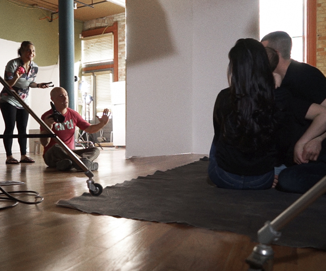 behind the scenes photo of a photographer directing a family in a family photo shoot