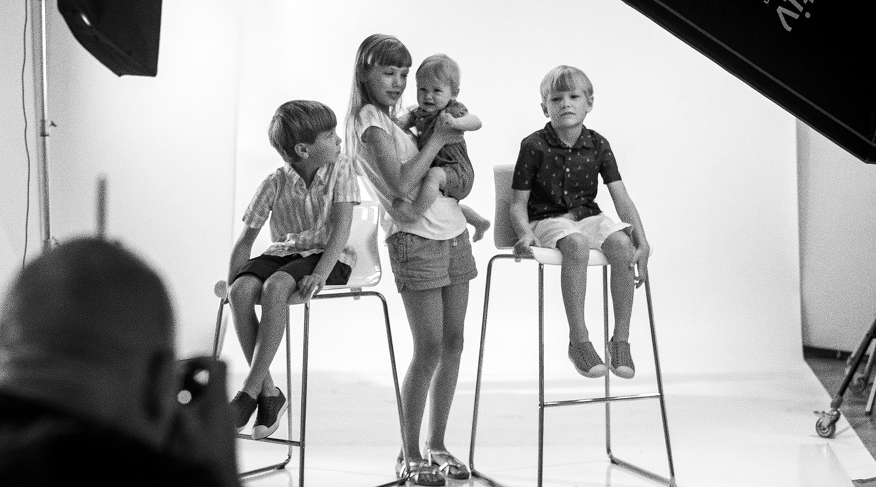 black and white behind the scenes shot of kids having their picture taken in the studio